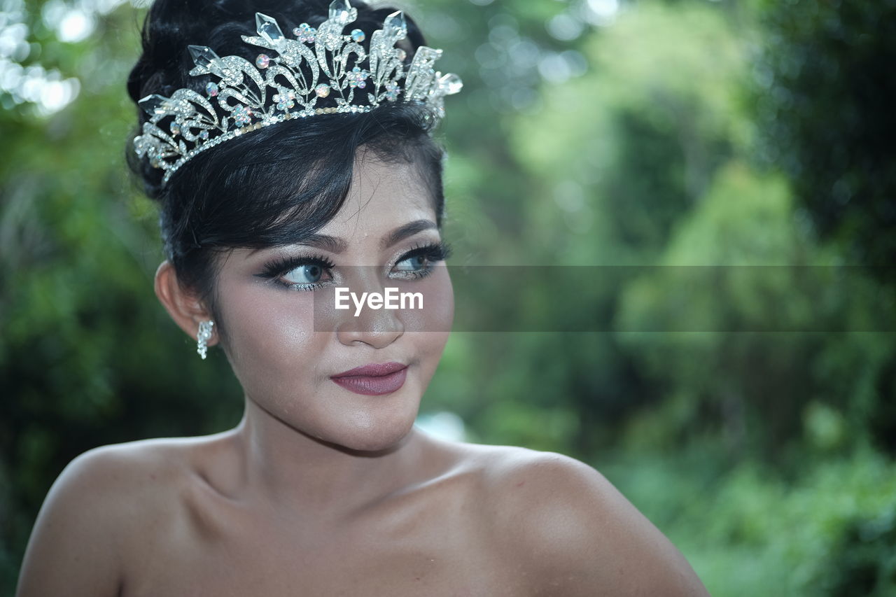 Beautiful young woman looking away while wearing tiara