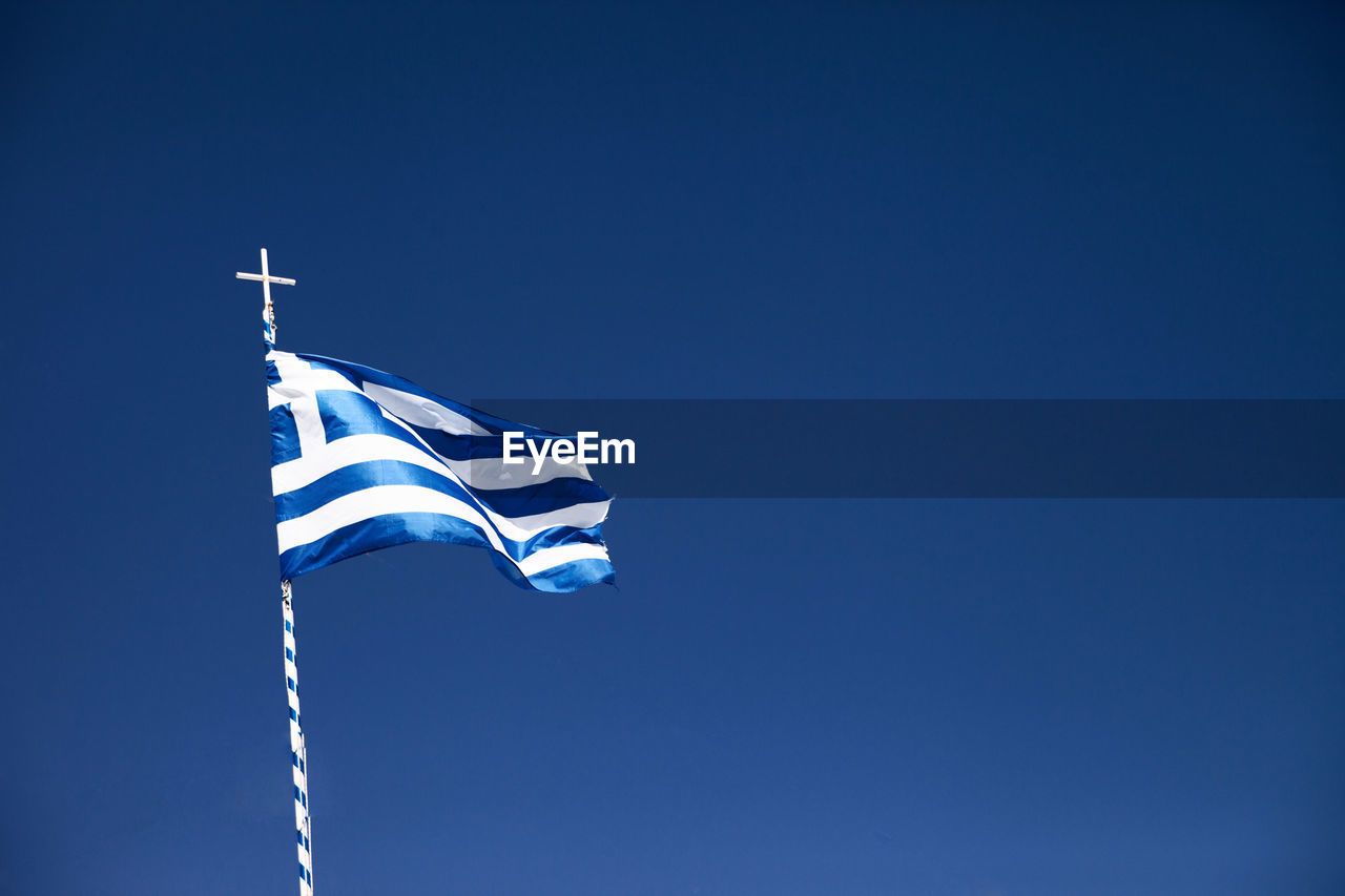 LOW ANGLE VIEW OF FLAG FLAGS AGAINST CLEAR BLUE SKY