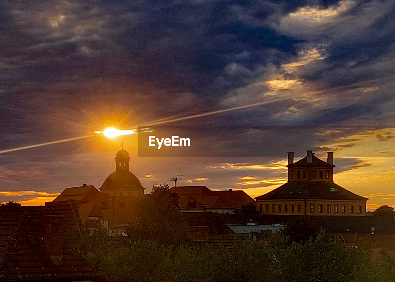 architecture, sky, sunset, built structure, cloud, evening, building exterior, building, dawn, religion, nature, travel destinations, history, sunlight, belief, sun, afterglow, place of worship, the past, horizon, city, travel, spirituality, landscape, temple - building, beauty in nature, no people, outdoors, tourism, environment, house, dramatic sky, orange color, scenics - nature, ancient, sunbeam, silhouette, tower, cityscape, business finance and industry