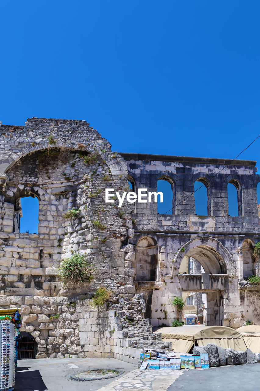architecture, history, built structure, the past, landmark, clear sky, town, travel destinations, sky, blue, arch, tourism, ancient history, ruins, ancient, travel, nature, building exterior, old ruin, vacation, day, old, sunny, city, outdoors, no people, ruined, building
