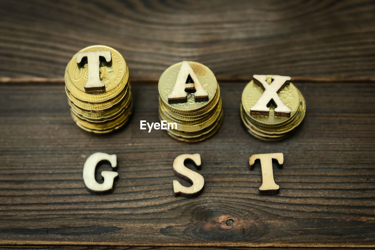 High angle view of coins with tax and gst text on table