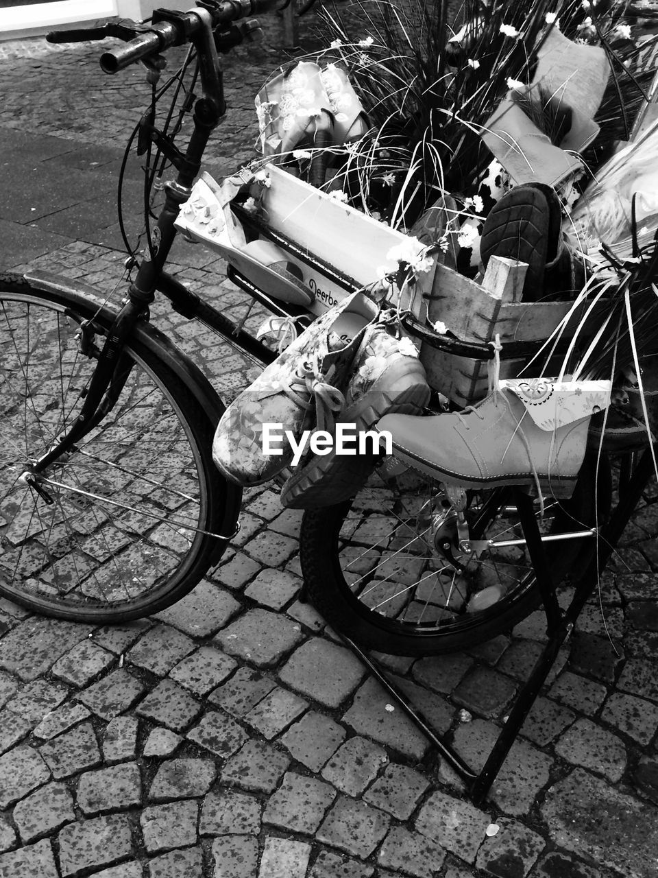 BICYCLE PARKED BY COBBLESTONE STREET