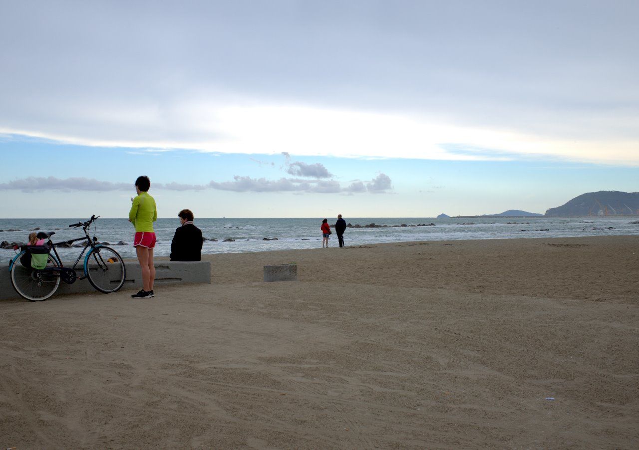 PEOPLE ON BEACH AGAINST SEA