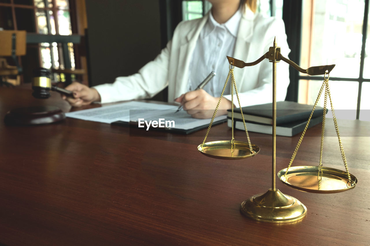 Midsection of lawyer sitting on table