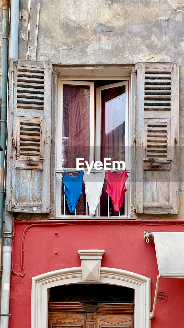 architecture, building exterior, window, built structure, house, red, no people, facade, building, day, home, wall, wood, urban area, residential district, door, blue, outdoors, interior design, old, closed, laundry, entrance, hanging, room