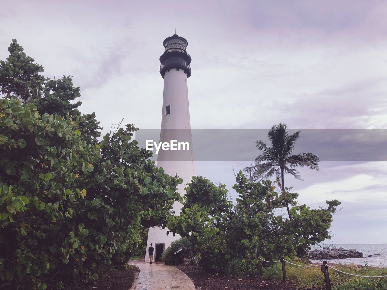 Lighthouse amidst trees and buildings against sky, miami 