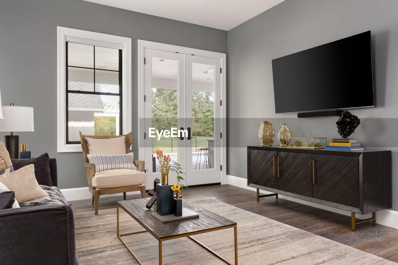 Beautiful living room in new luxury home with french doors and big tv