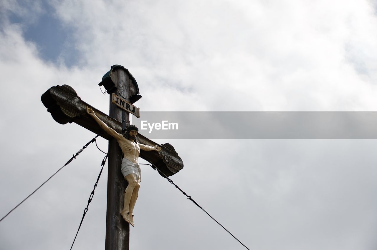 LOW ANGLE VIEW OF BIRD PERCHING ON CABLE