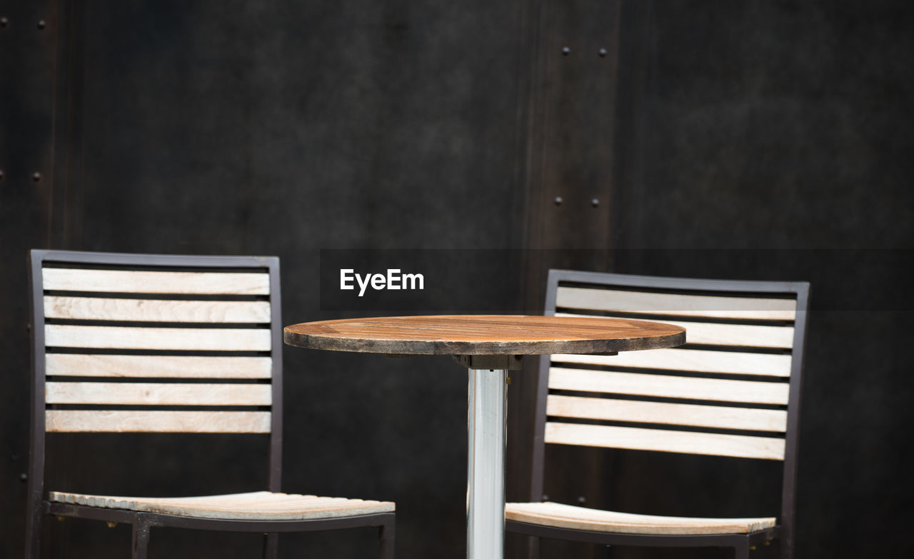 Empty chairs and table at sidewalk cafe