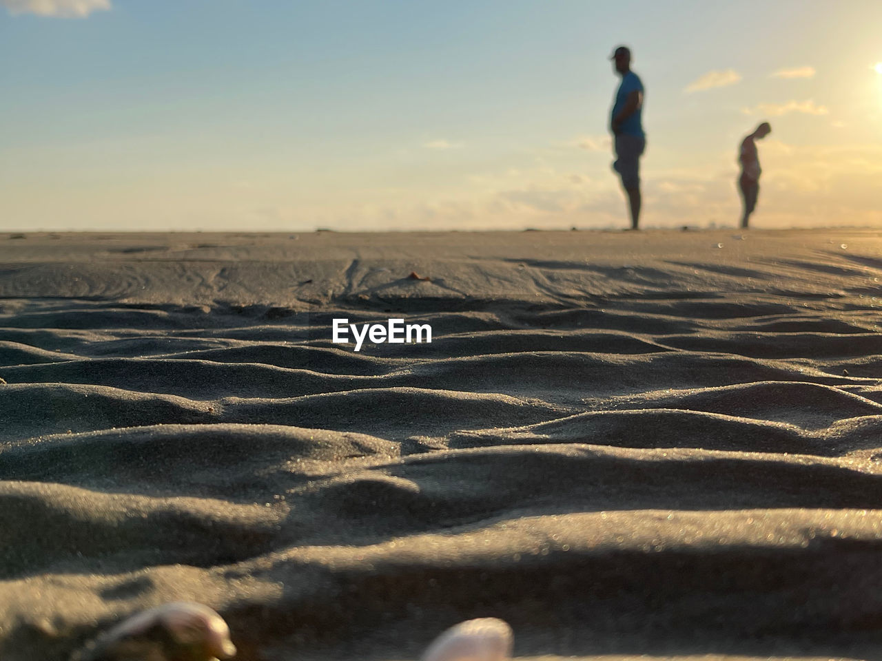 PEOPLE WALKING ON SAND DUNE