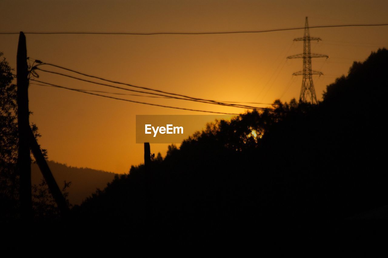 SILHOUETTE ELECTRICITY PYLON AGAINST SKY DURING SUNSET