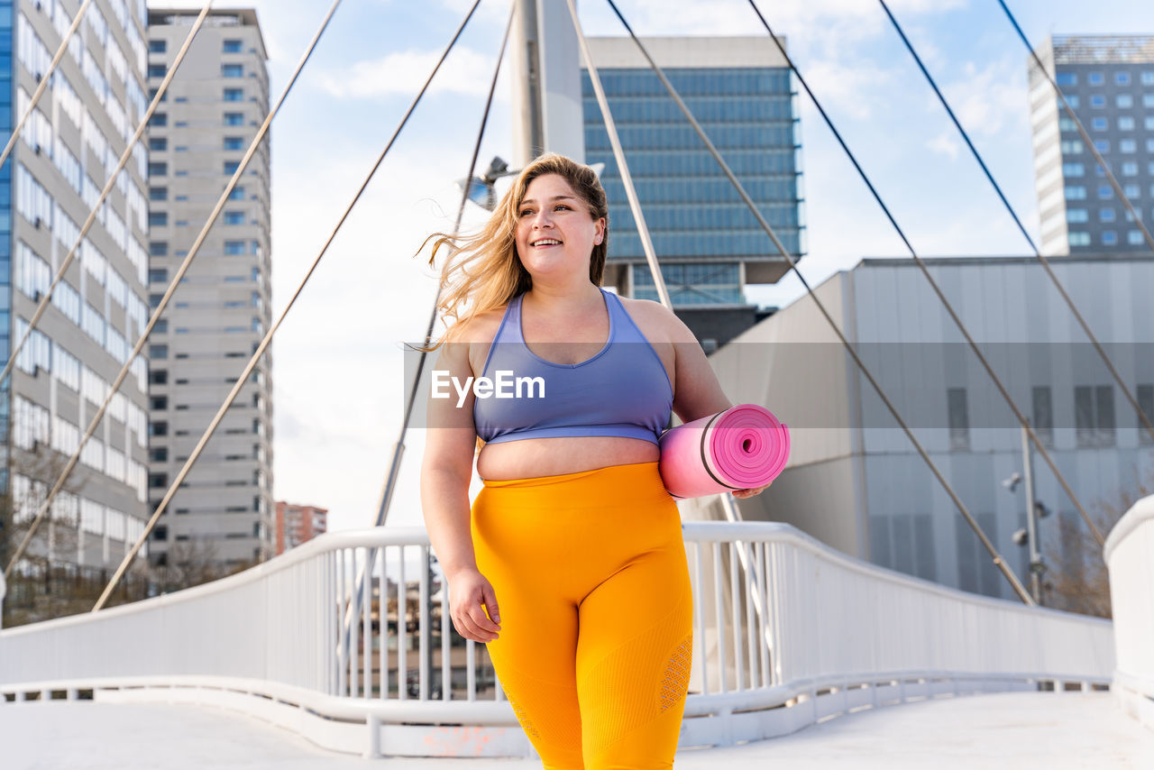 Young woman in sports clothing on footbridge