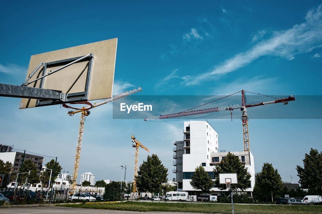 Cranes against sky in city