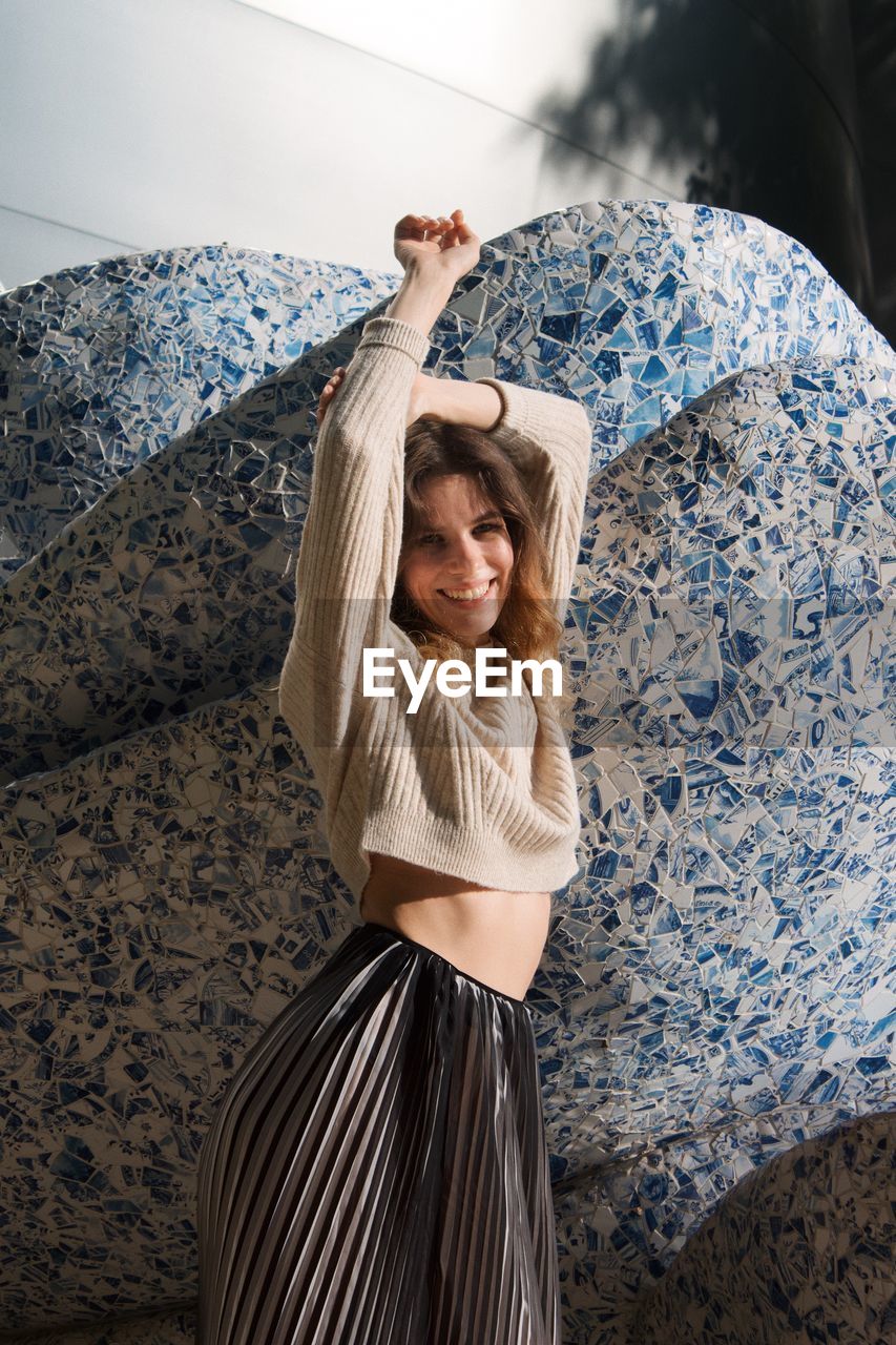 Rear view of young woman standing against wall