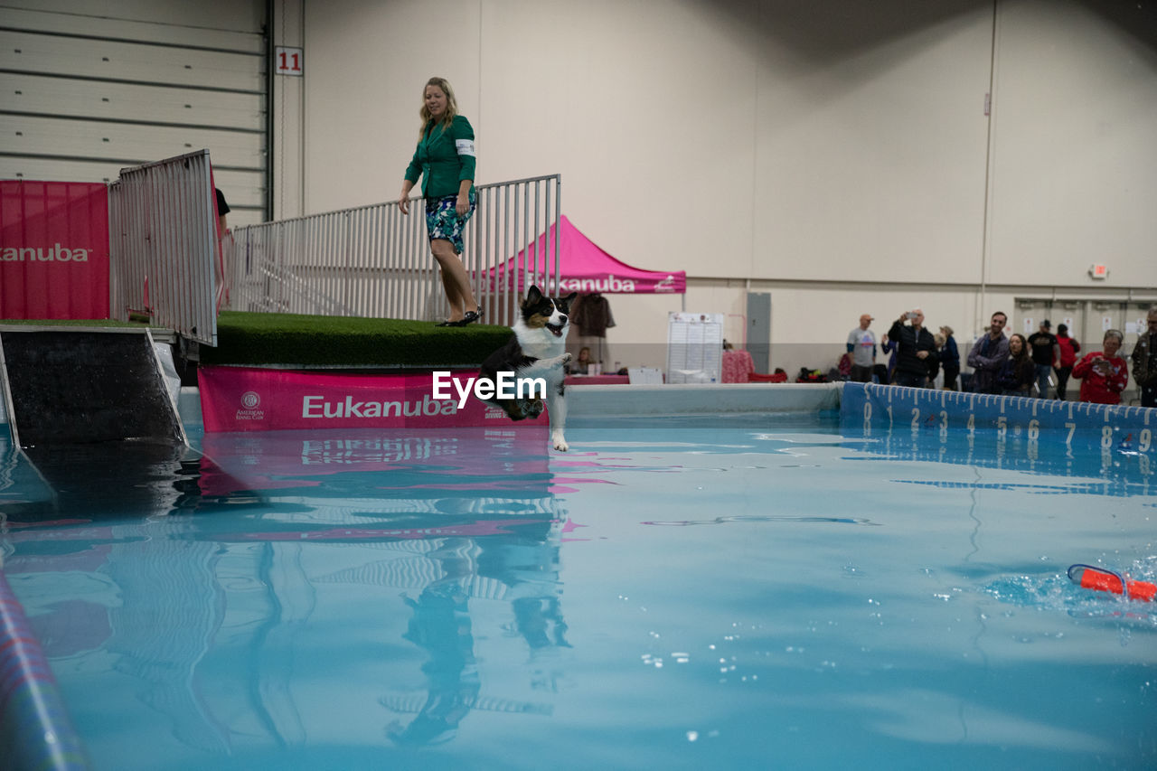 PEOPLE IN SWIMMING POOL AGAINST THE WALL