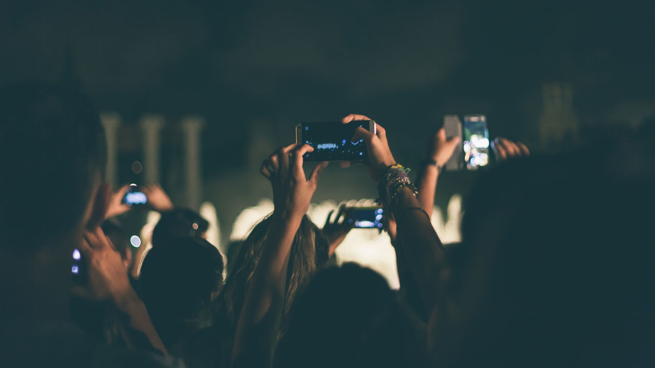 People recording concert with mobile phones