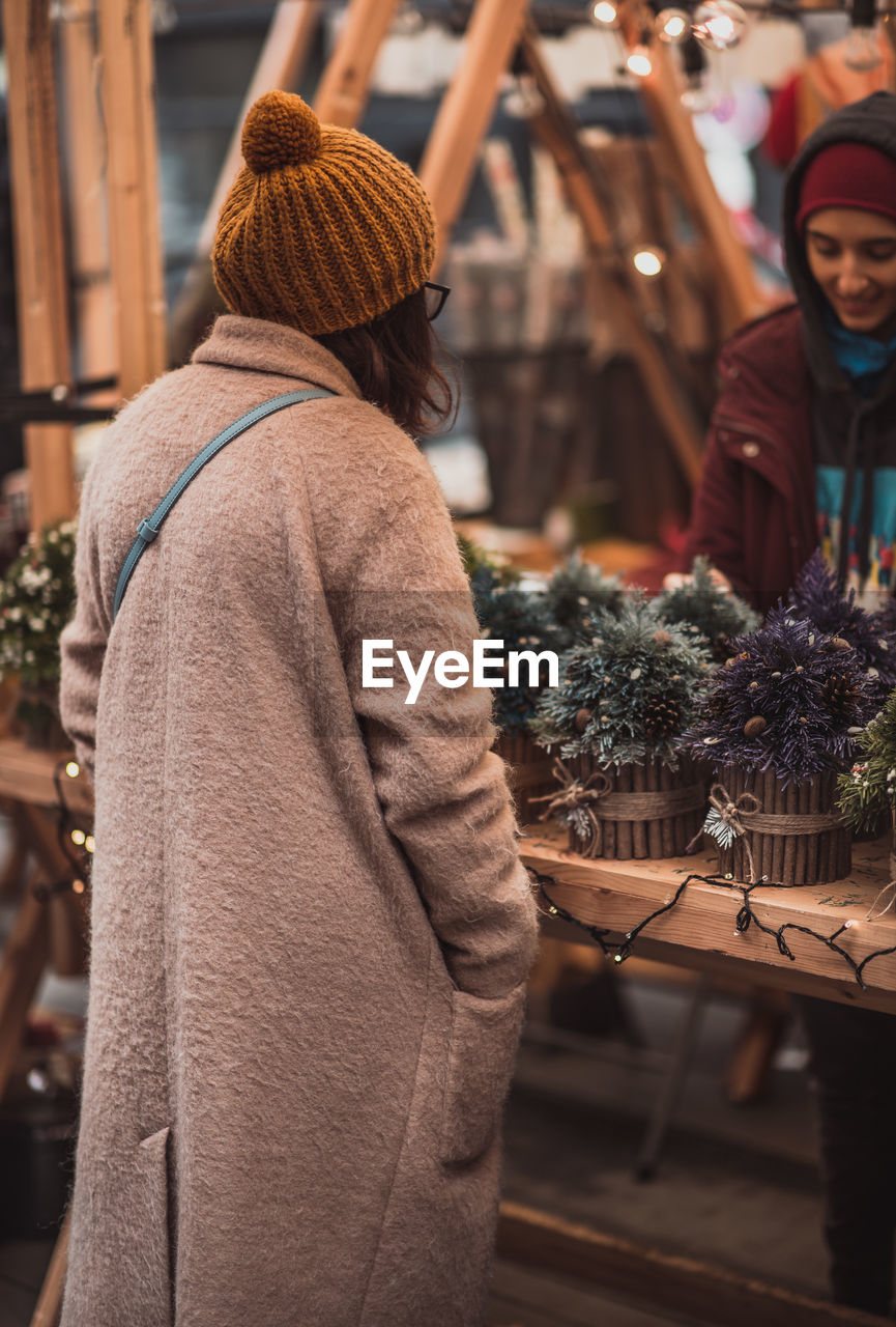 Rear view of woman standing at christmas market
