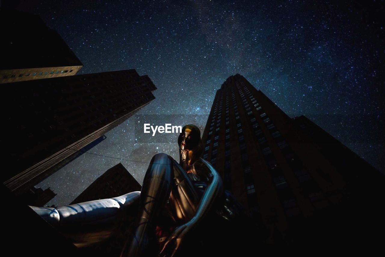 LOW ANGLE VIEW OF PERSON AGAINST SKY AT NIGHT