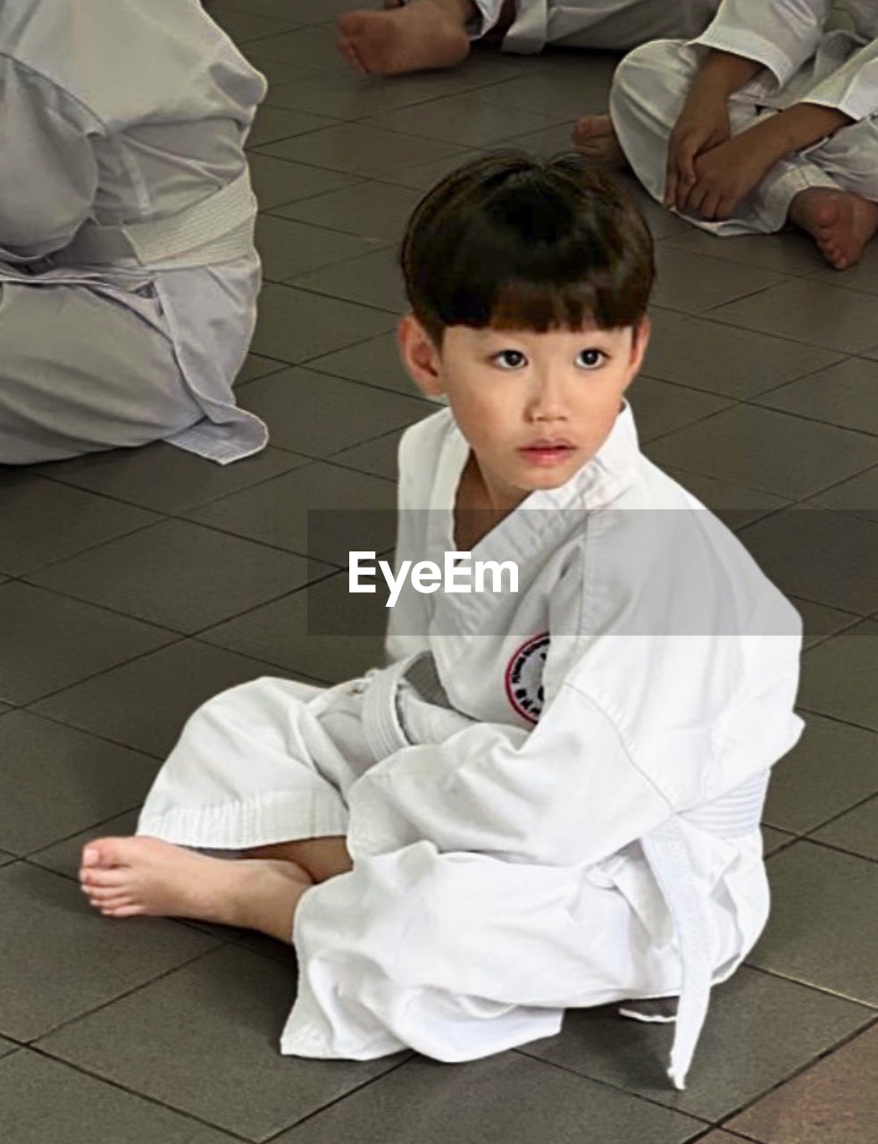 martial arts, sports, judo, childhood, child, men, karate, sitting, full length, combat sport, high angle view, flooring, contact sport, portrait, looking at camera, female, indoors, two people, women, tiled floor, lifestyles, clothing, individual sports, tile, adult, jujutsu, robe, barefoot, baby