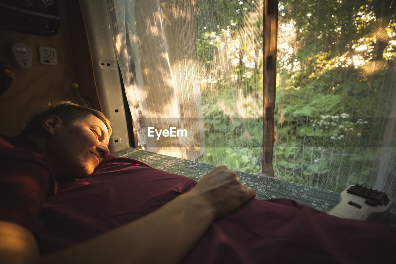 Young man sleeping in camper van