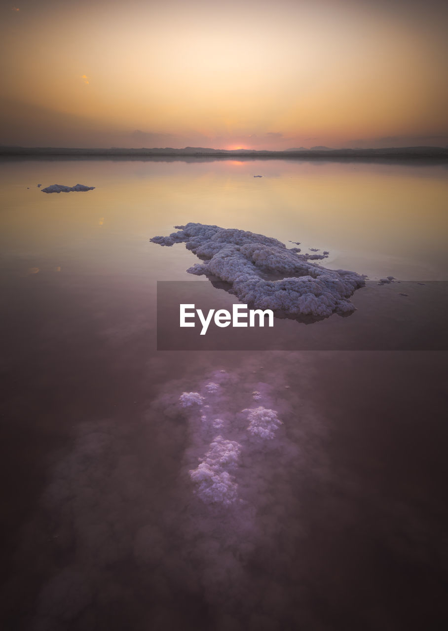 Lake with clear pink water and salt located in famous national park in torrevieja city of spain in evening time during sunset