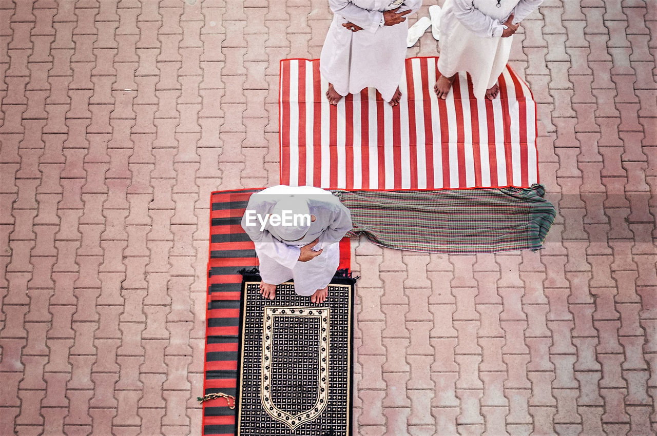 High angle view of people praying on footpath