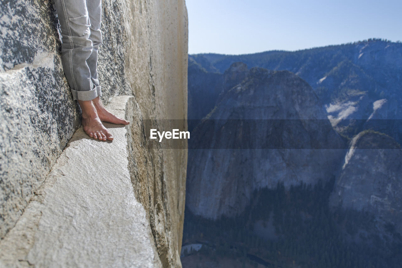 Man standing on a ledge, view of bare foot, very high el capitan