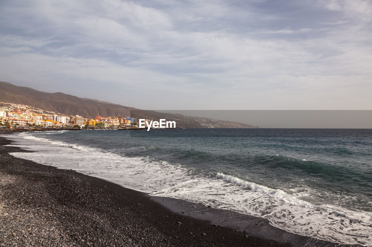 SCENIC VIEW OF SEA BY MOUNTAINS AGAINST SKY