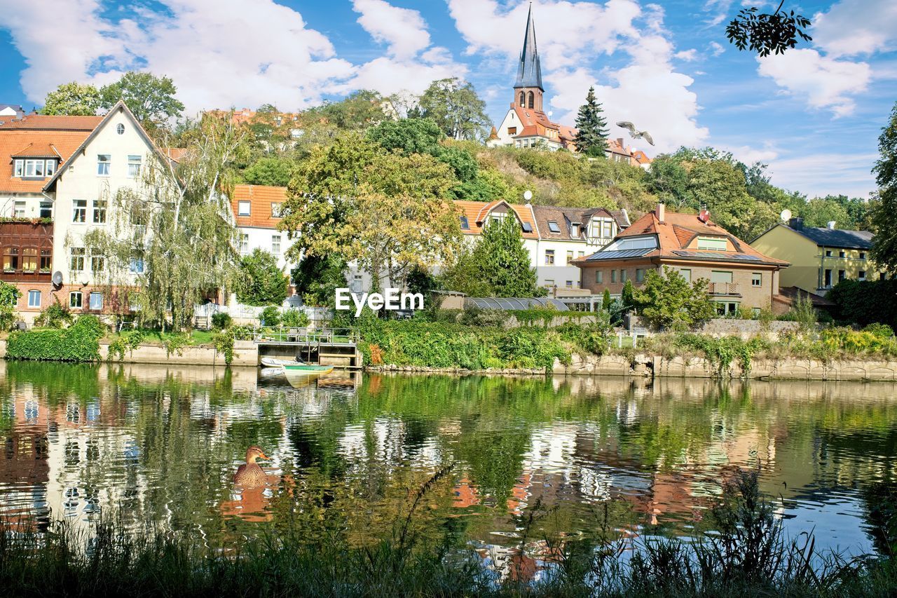Reflection of trees and buildings in lake