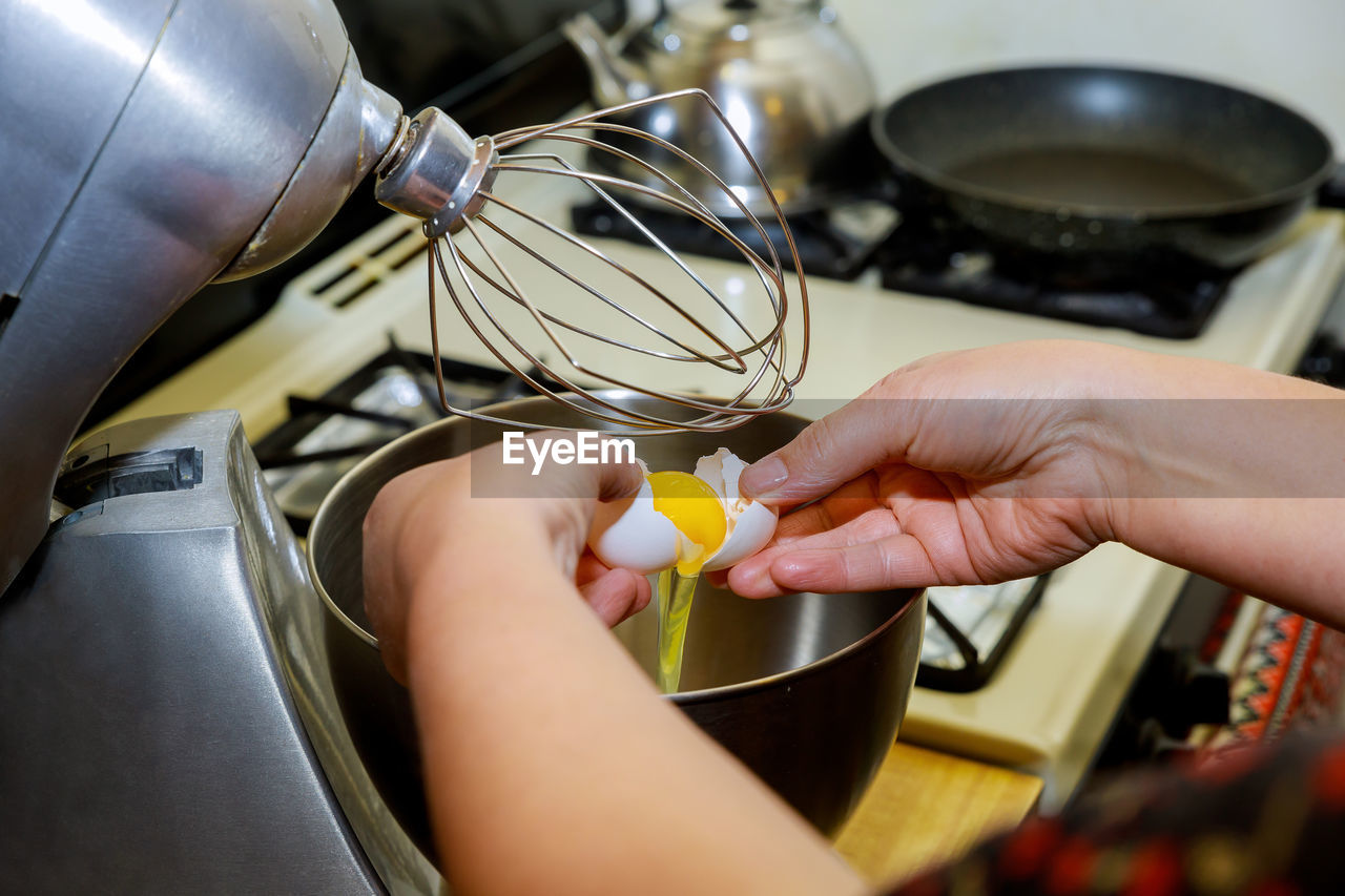 HIGH ANGLE VIEW OF PERSON PREPARING FOOD AT HOME