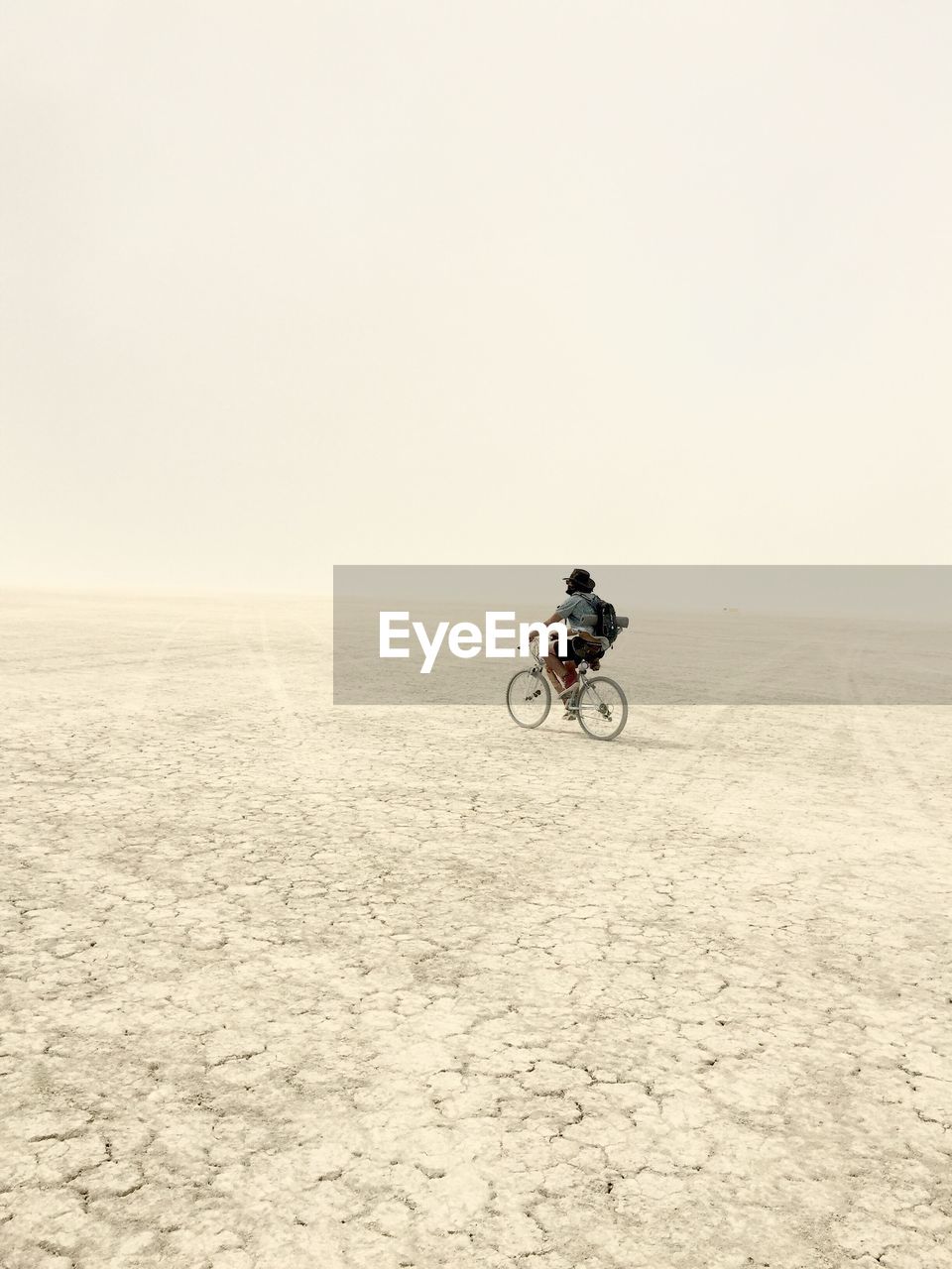 Full length of man riding bicycle at desert