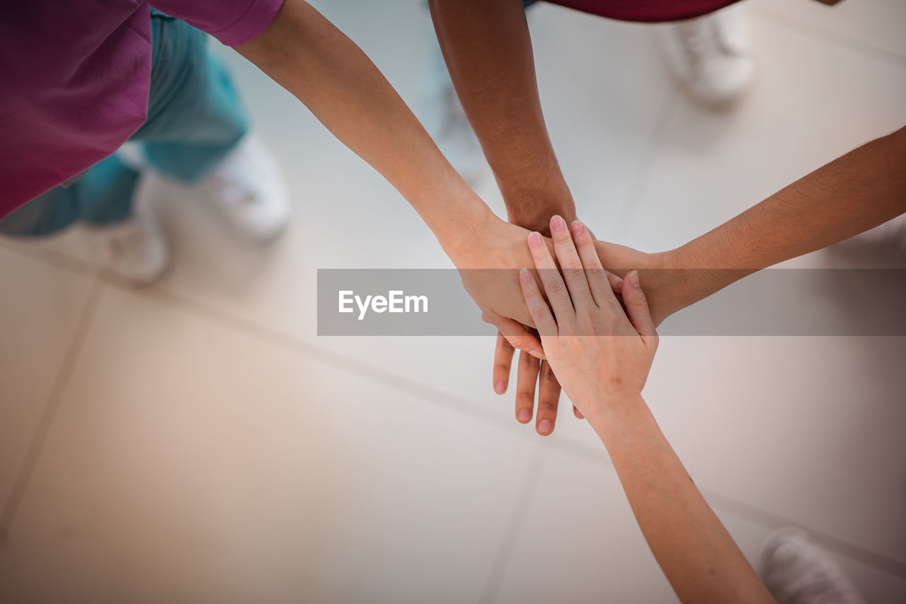 High angle view of kids stacking hands at home