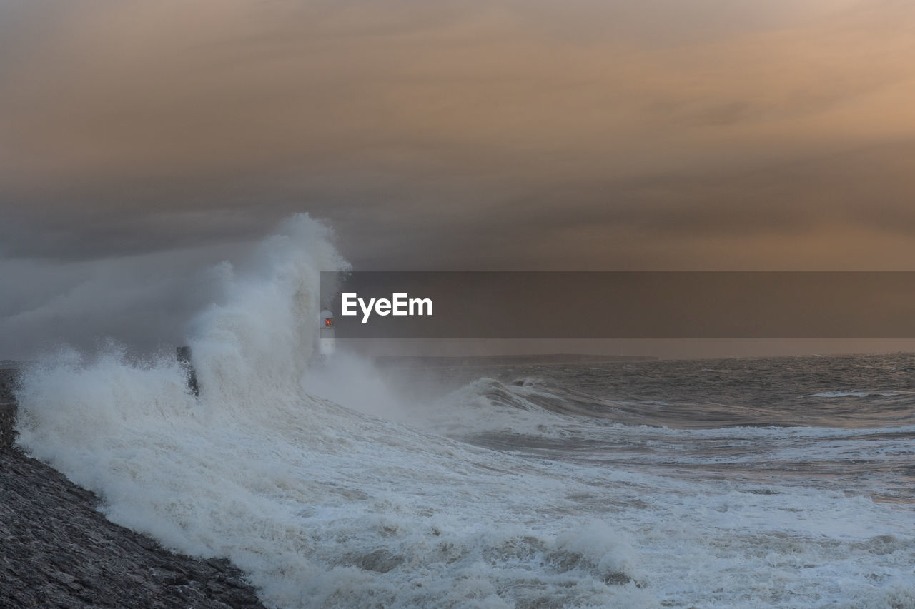 PANORAMIC VIEW OF SEA WAVES AGAINST SKY DURING SUNSET