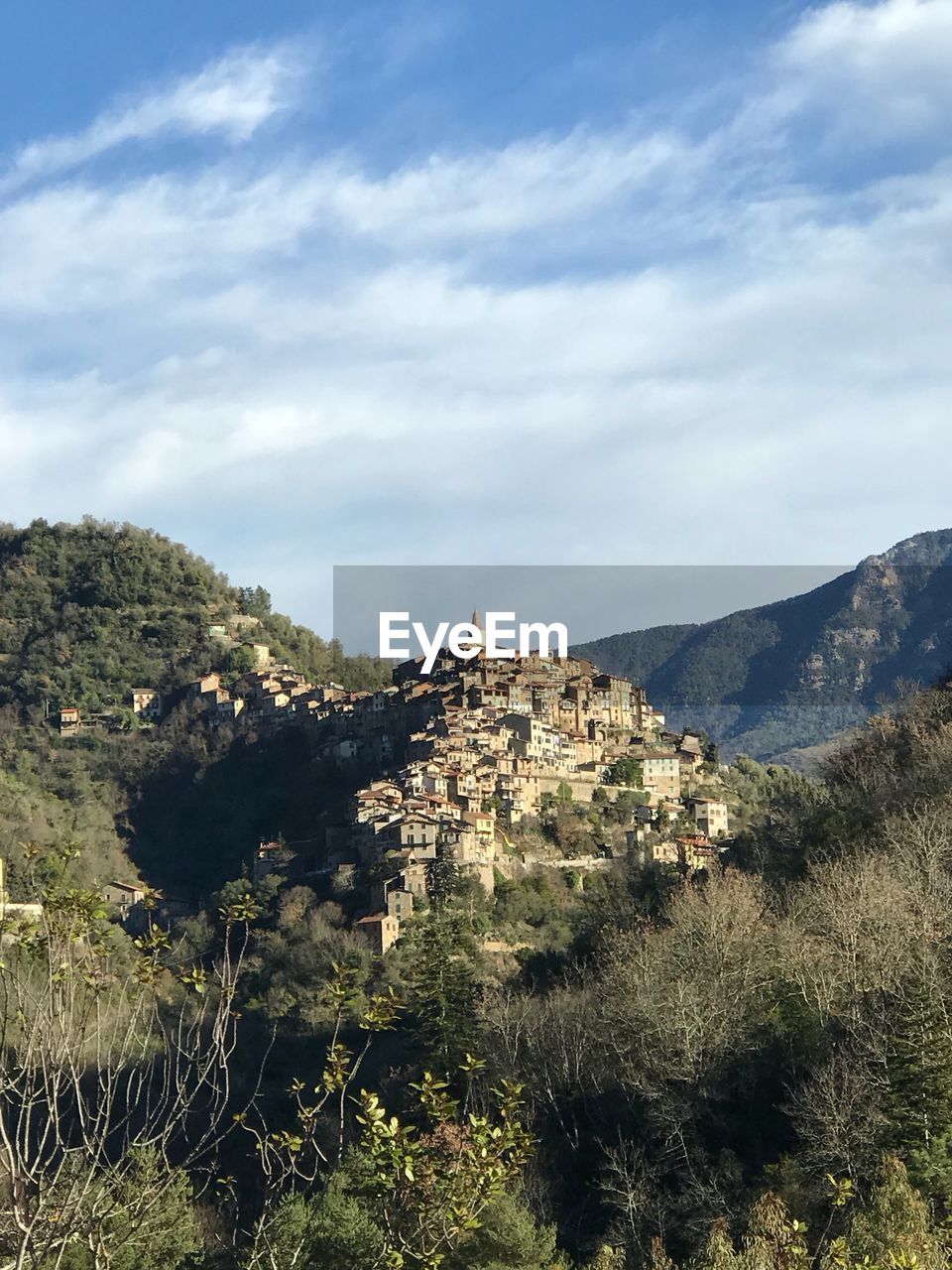 BUILT STRUCTURE BY TREES AND BUILDINGS AGAINST SKY