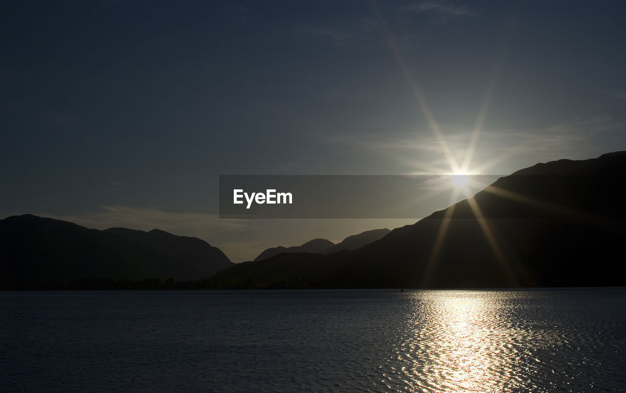 Scenic view of lake against sky at sunset