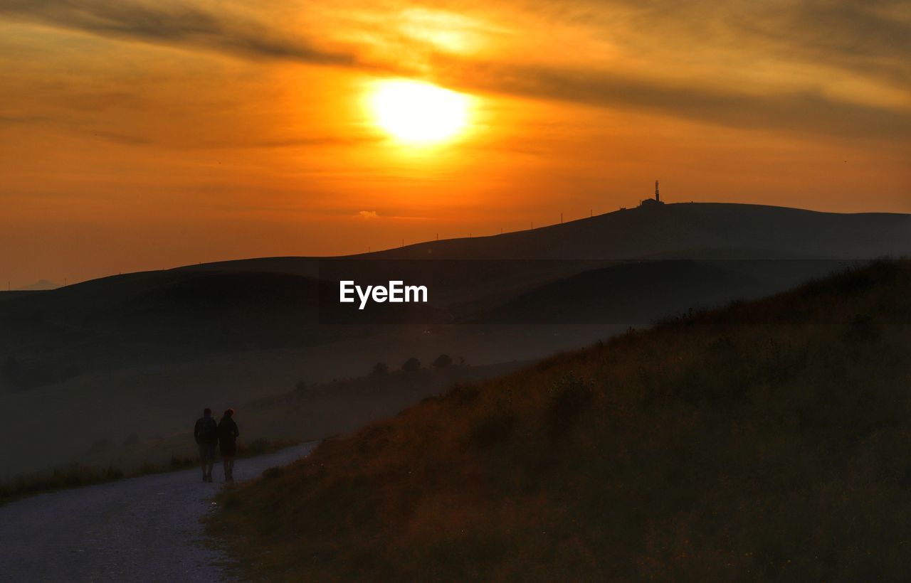 SCENIC VIEW OF SILHOUETTE MOUNTAINS DURING SUNSET
