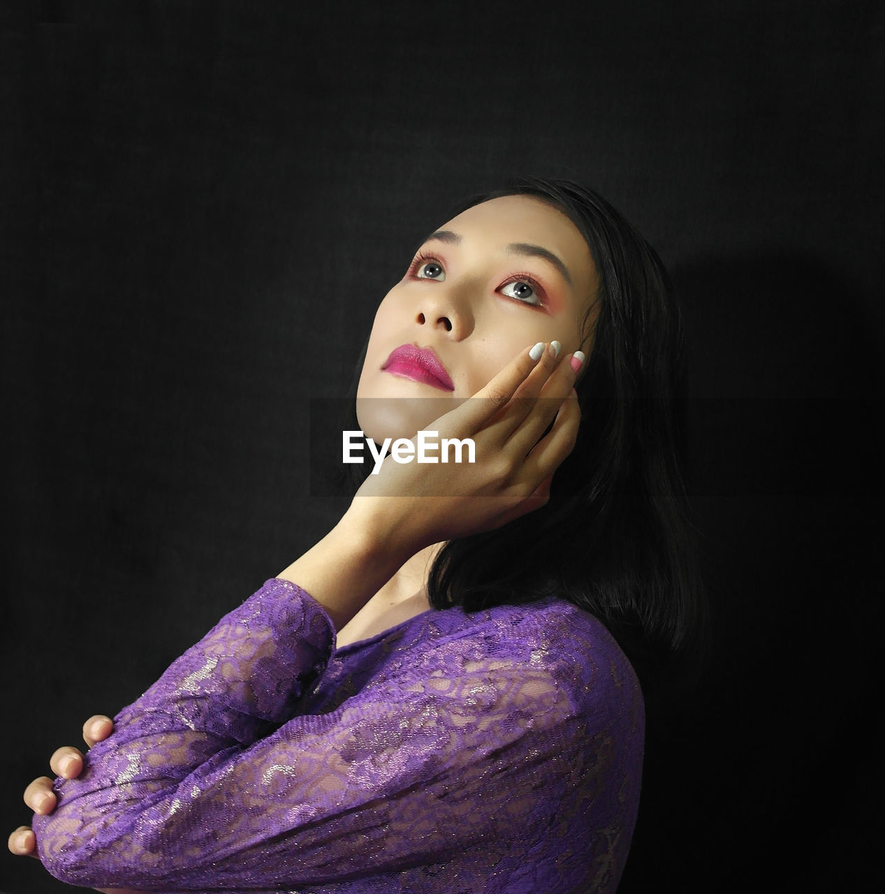 Portrait of a beautiful young woman over black background