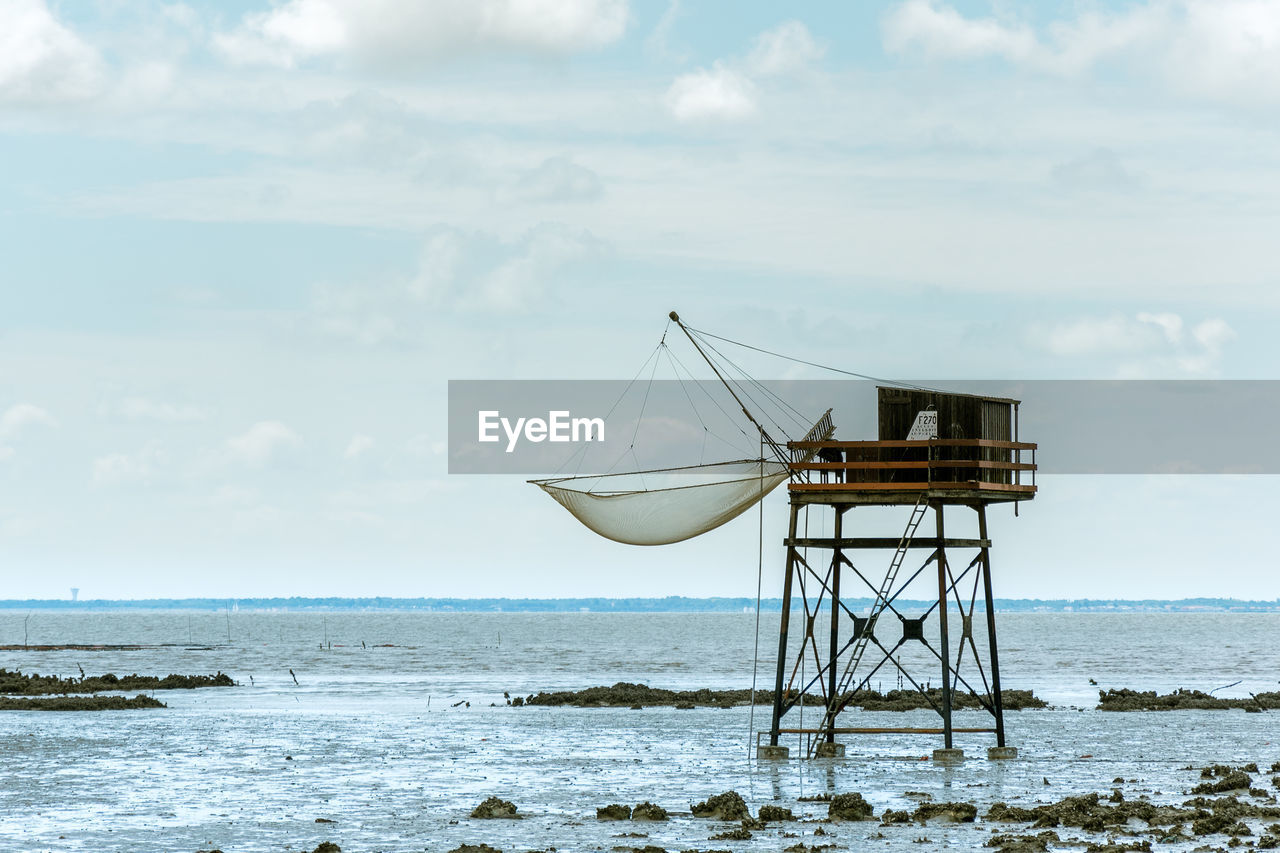 Fishing net hanging on built structure over sea