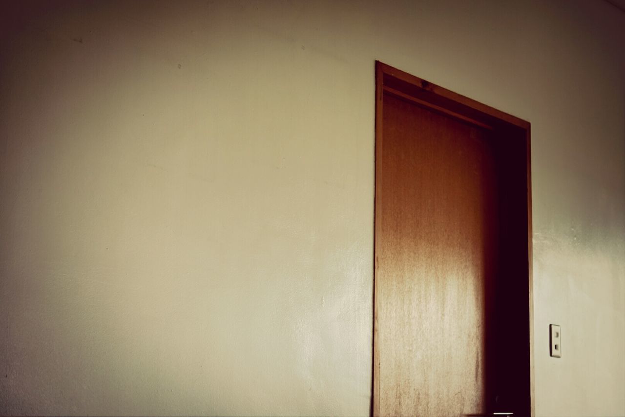 Wooden door in white wall