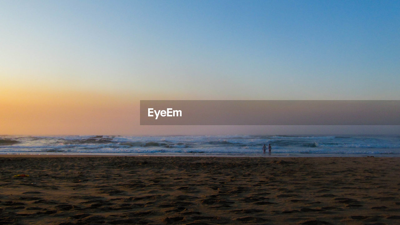 SCENIC VIEW OF BEACH DURING SUNSET