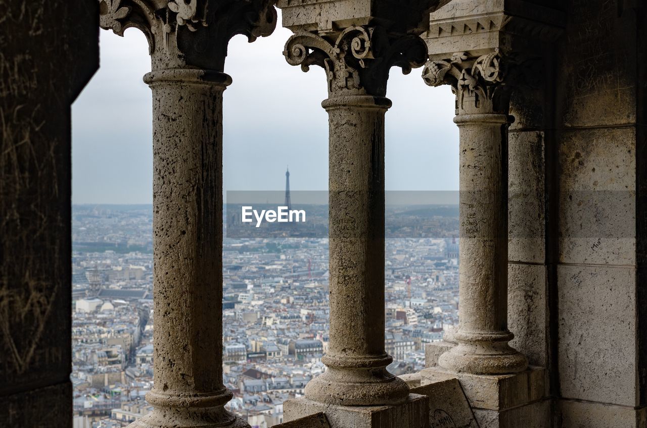 Distant view of eiffel tower seen through historic window