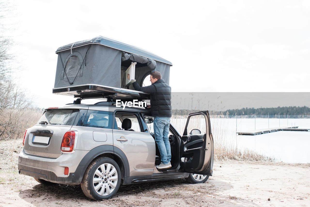 Man setting up a roof top tent for an office to social distance