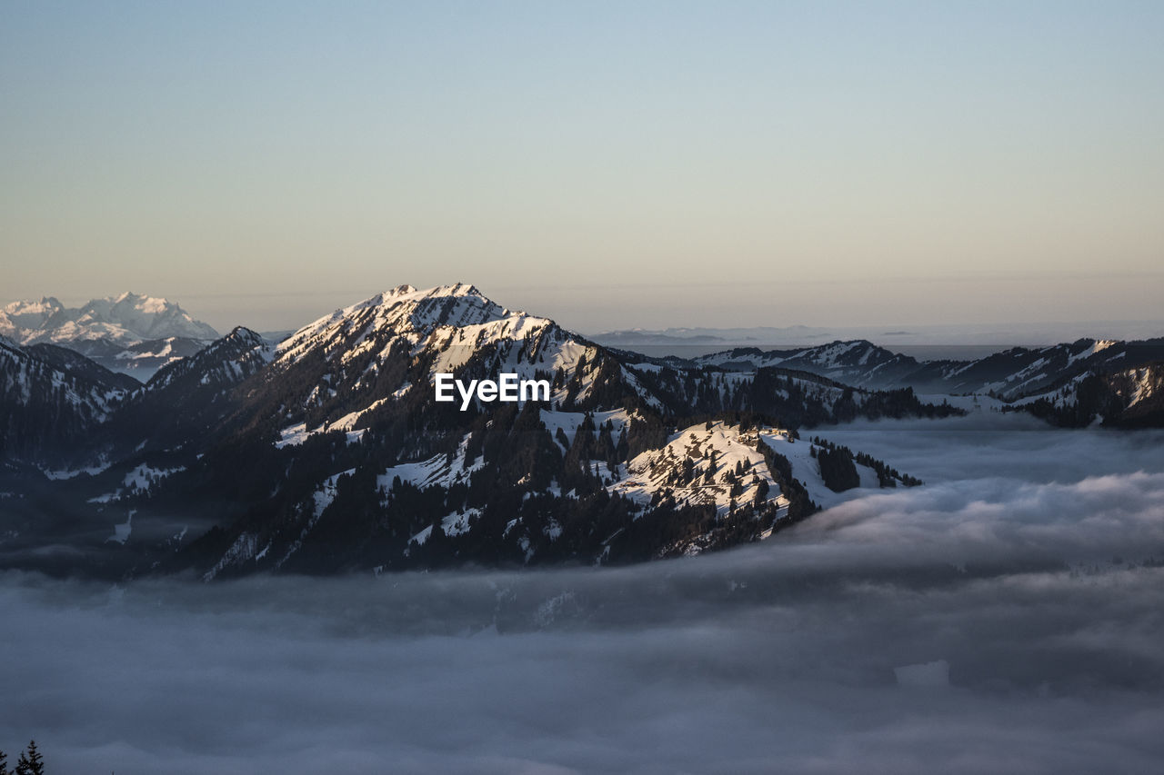 Snowcapped mountains against clear sky during winter
