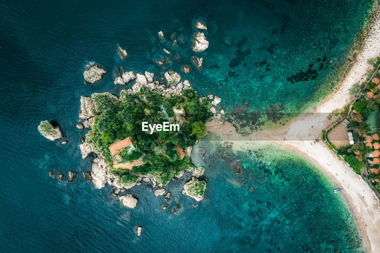 HIGH ANGLE VIEW OF ROCKS ON SHORE AT SEA