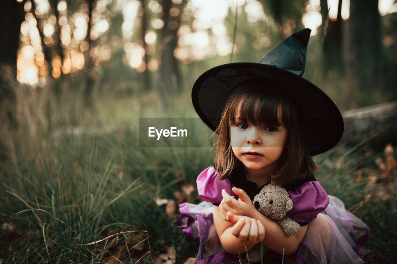 PORTRAIT OF GIRL WITH TOY IN FIELD