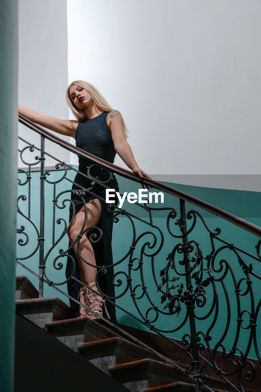 Low angle view of beautiful woman wearing dress while standing on staircase