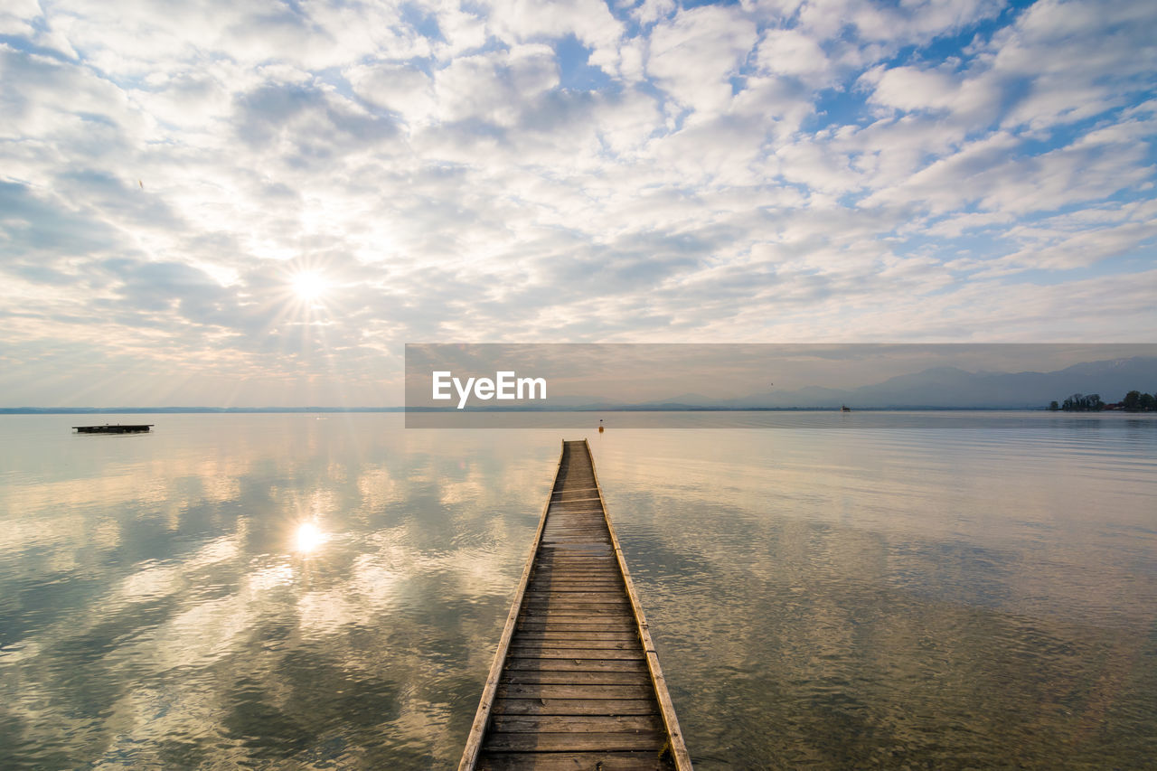 High angle view of pier over lake against cloudy sky during sunrise