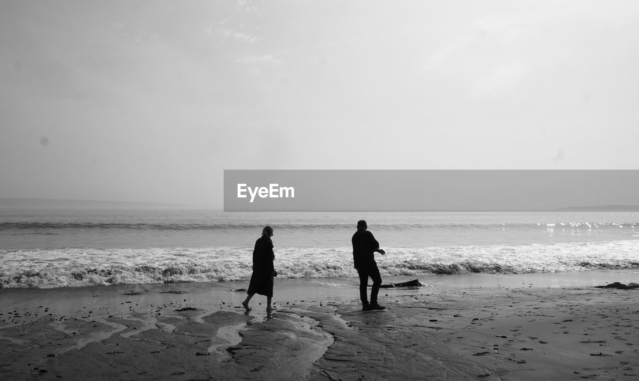 People at beach against sky