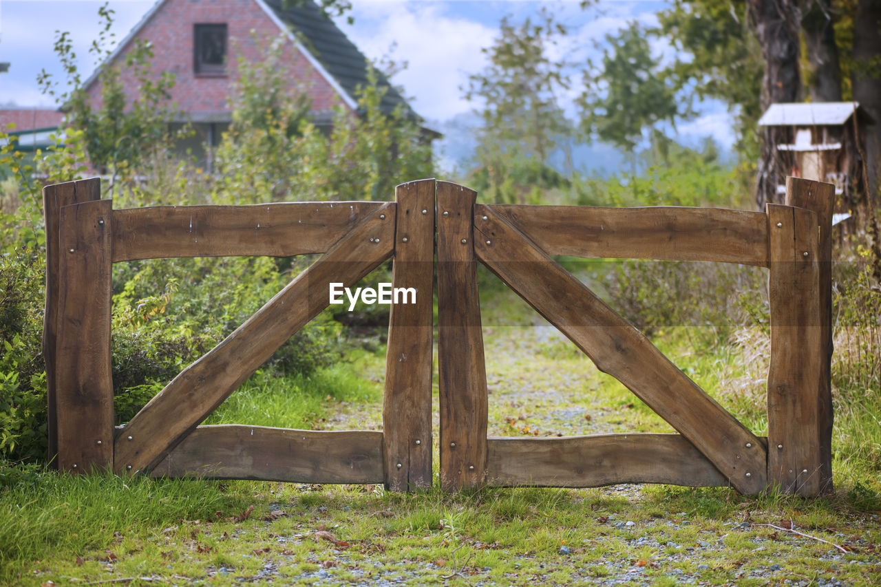 Frontal view of wooden entrance gate with a shallow depth of field in a rural setting in daylight