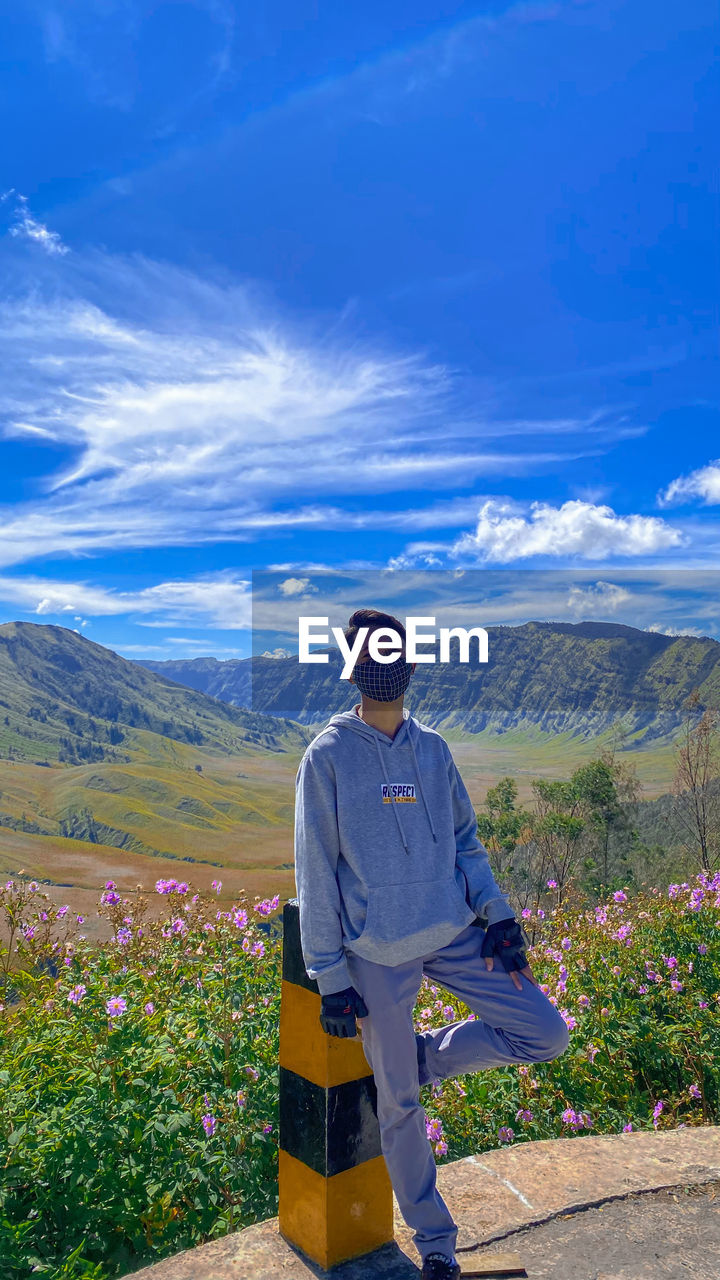 Man standing on mountain against blue sky